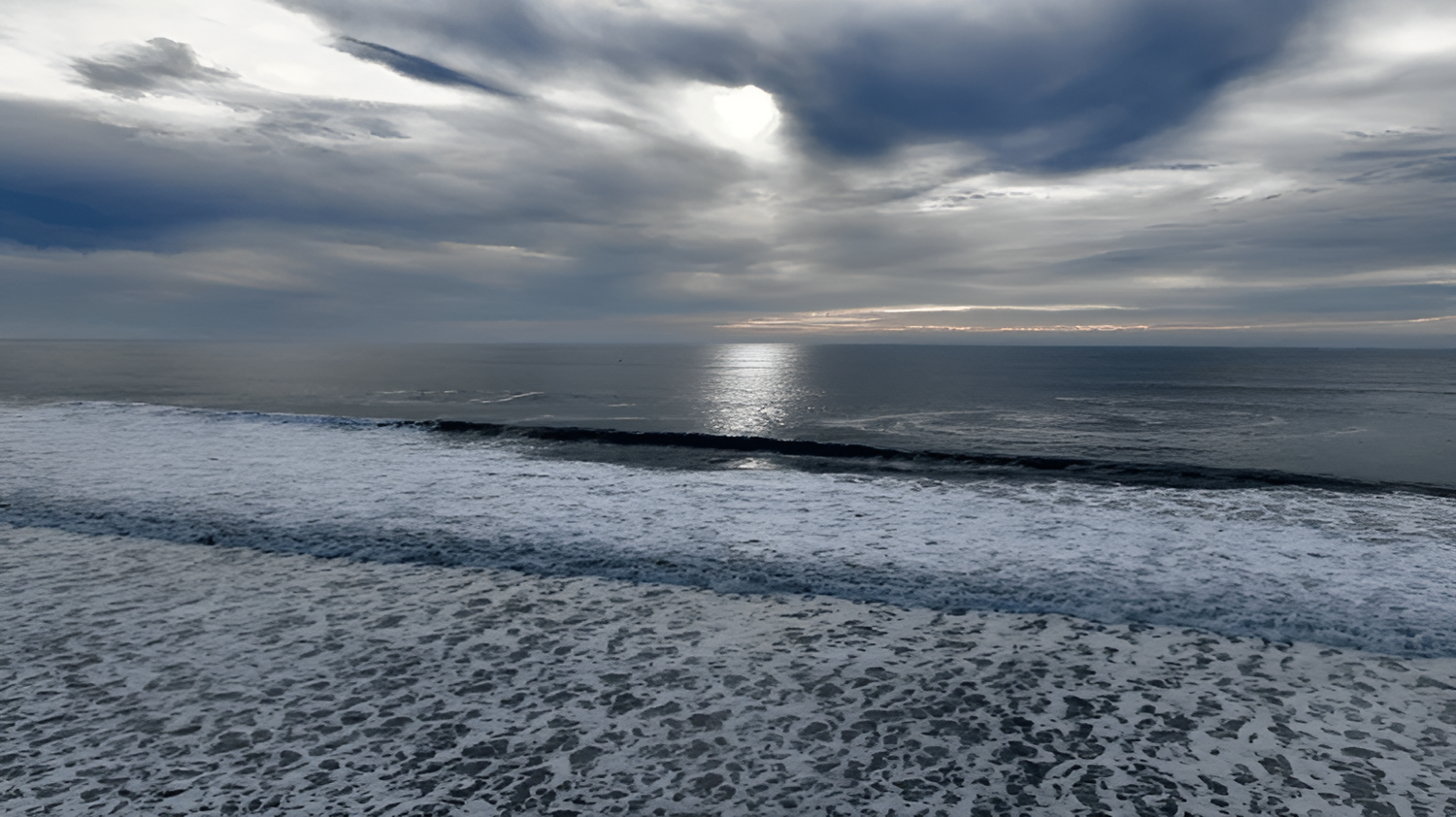 Wide aerial view of open water and beach in San Diego, shot from high above.